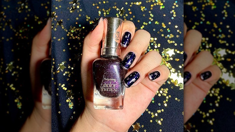 hand with purple celestial manicure