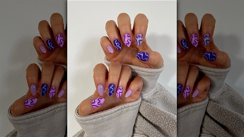 woman's hands purple squiggle manicure