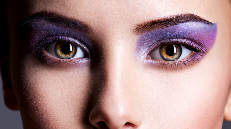 Woman wearing purple eyeshadow and lipstick