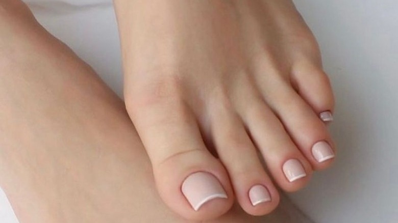 Woman with a pale pink French pedicure 