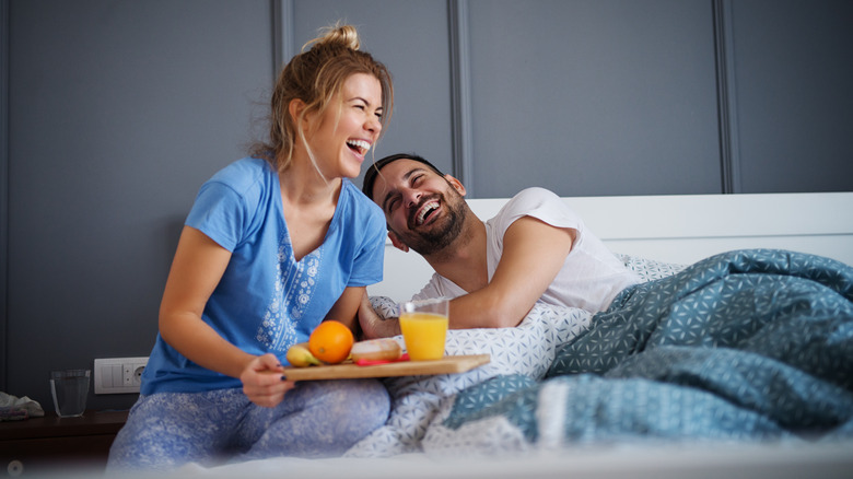 laughing couple in bed