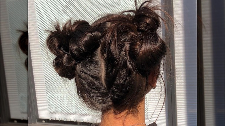 A woman with messy space buns