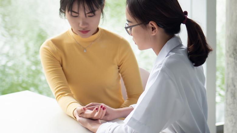 Chinese medicine practitioner with patient