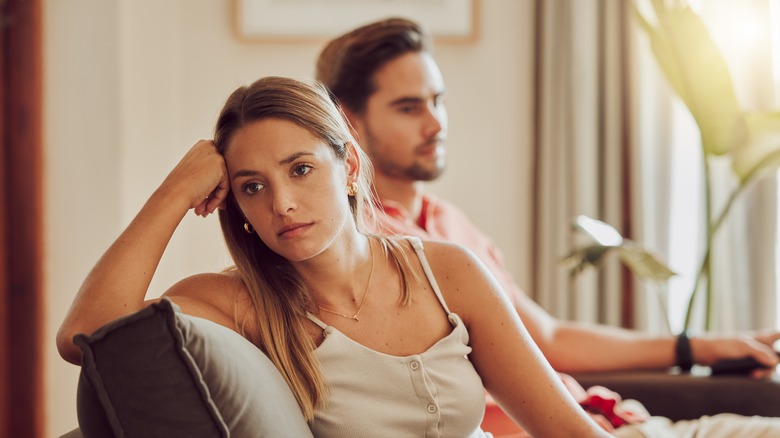 upset girlfriend sitting by boyfriend 