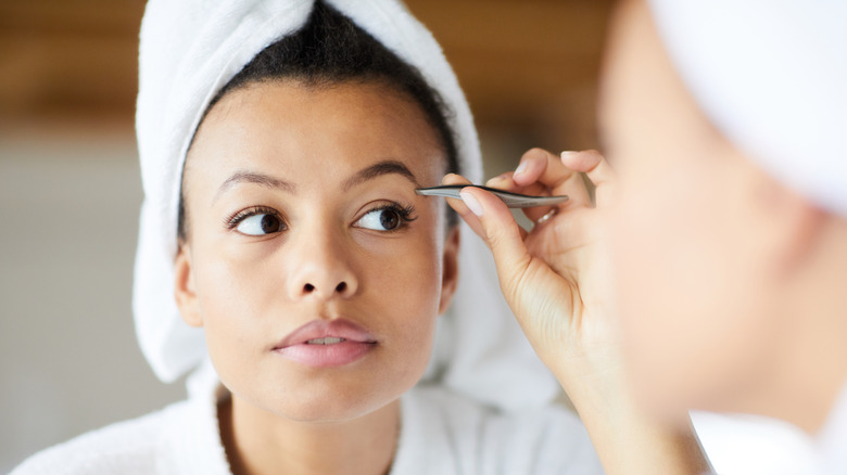 woman plucking eyebrows 