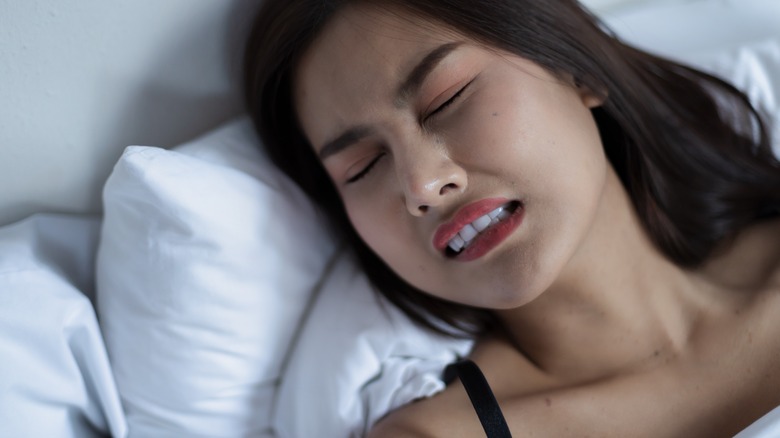 woman grinding teeth while sleeping