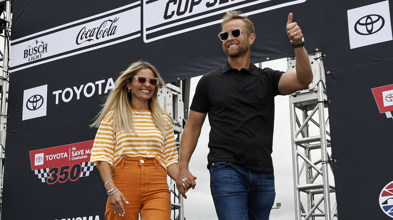 Candace Cameron Bure walks behind her husband Valeri at a NASCAR event.