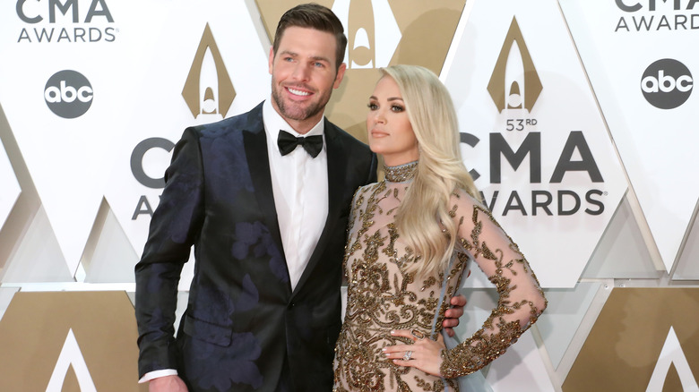 Carrie Underwood and Mike Fisher posing together on the CMA Awards red carpet.