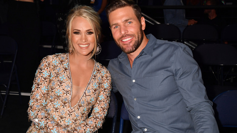 Carrie Underwood and Mike Fisher posing for a photo together.