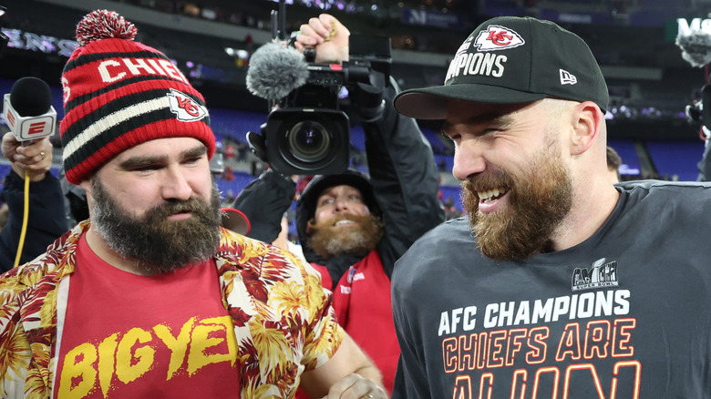 Jason and Travis Kelce on football field in front of a camera man