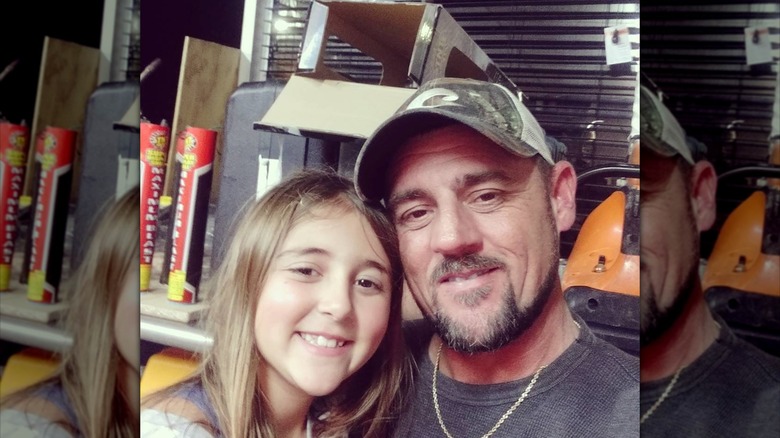 Jeremy Dufrene wearing a cap, posing for a photo with his daughter.