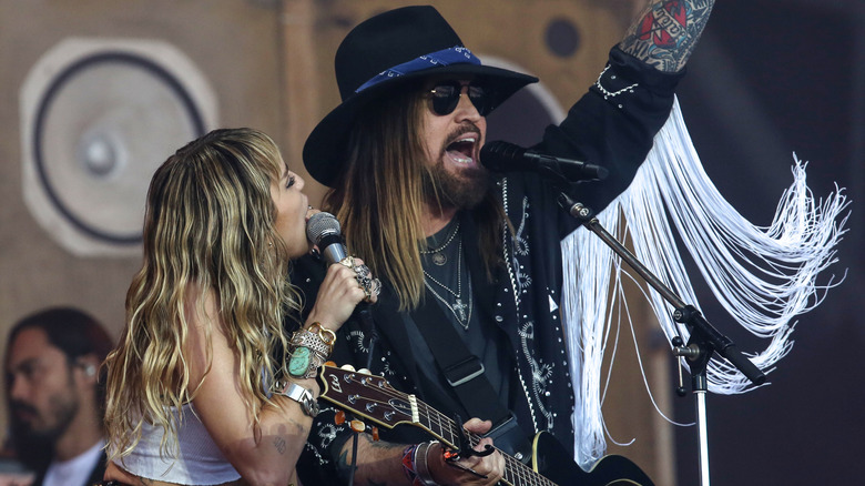 Miley Cyrus performing on stage with her father Billy Ray.