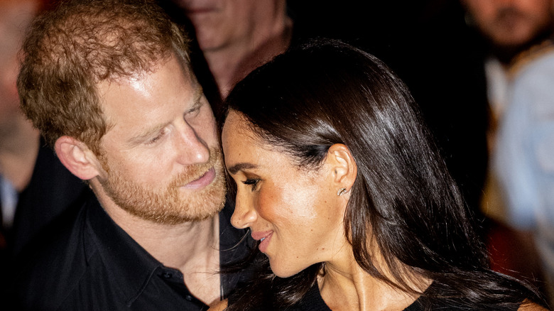 Prince Harry speaking closely to Meghan Markle.