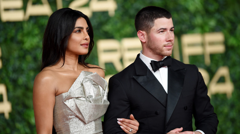 Priyanka Chopra and Nick Jonas posing together at a red carpet event in 2024.