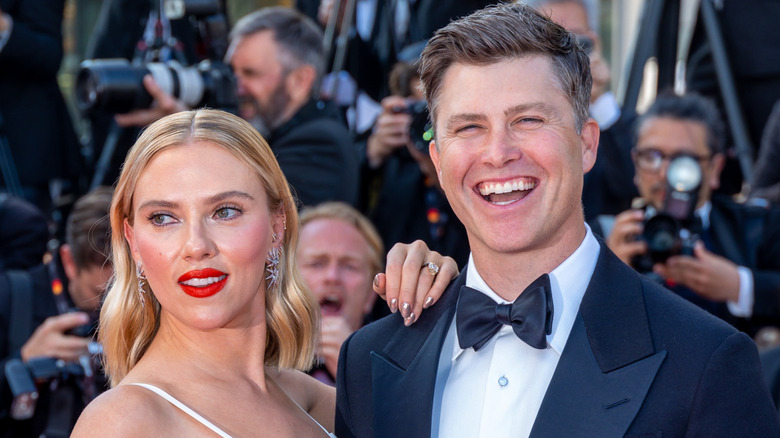 Colin Jost laughing on the red carpet with Scarlett Johansson.