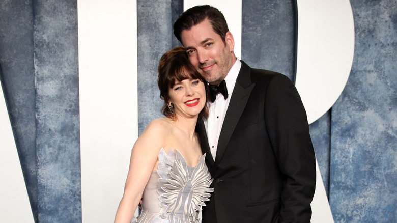 Zooey Deschanel and Jonathan Scott posing together on a red carpet.