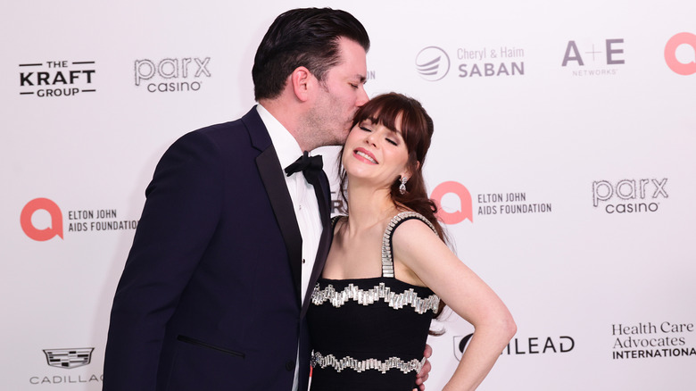 Jonathan Scott kissing Zooey Deschanel at a red carpet event.