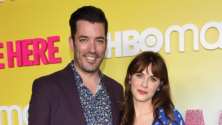 Zooey Deschanel and Jonathan Scott posing on a red carpet.