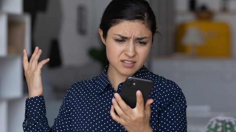 annoyed woman looking at phone