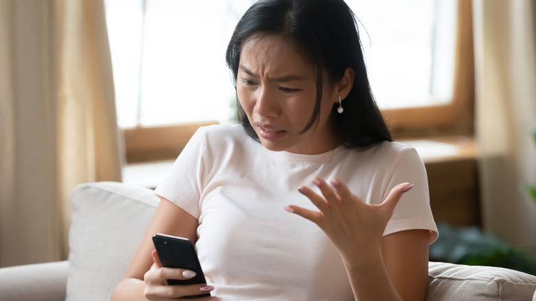 annoyed woman looking at phone