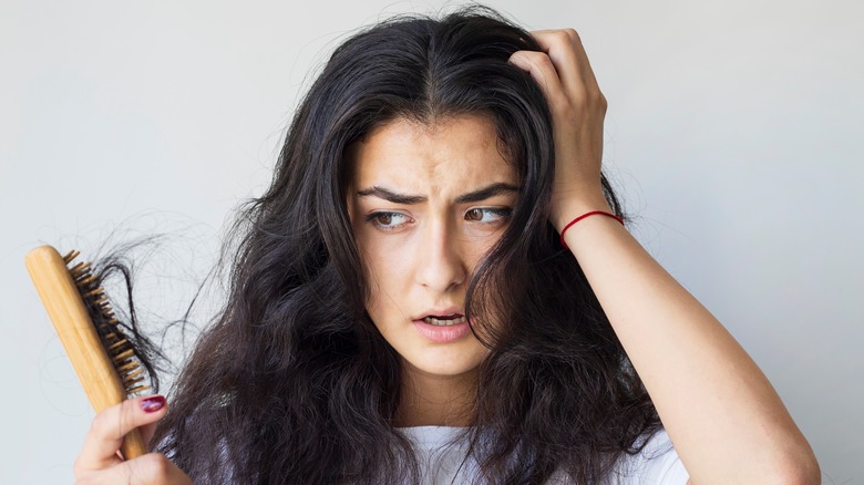 woman brushing damaged hair