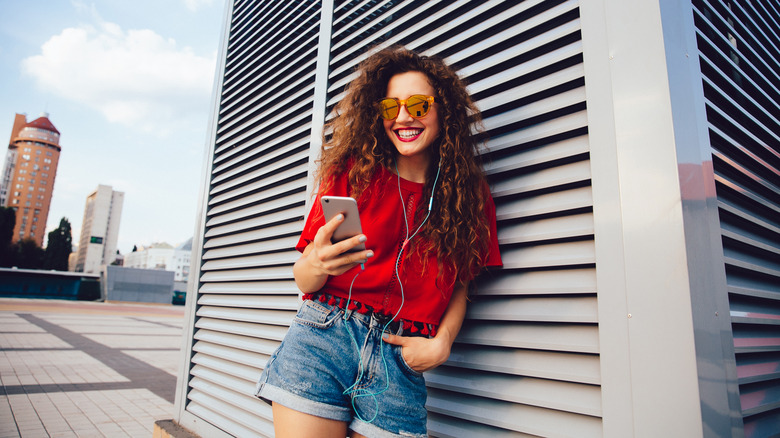 Curly-haired woman in red top, denim