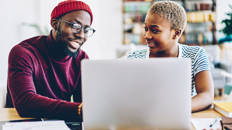 Couple researches together on laptop