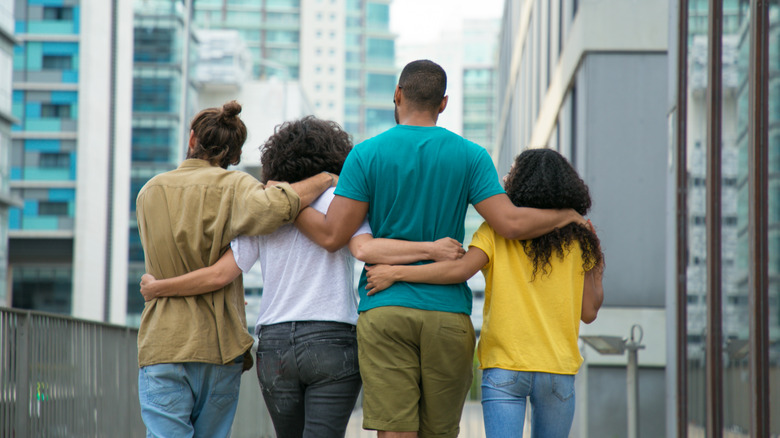 Four people with arms around each other