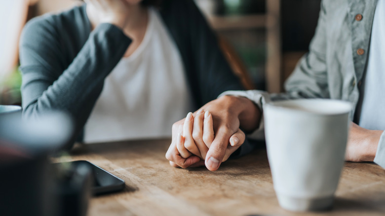 couple holding hands at table