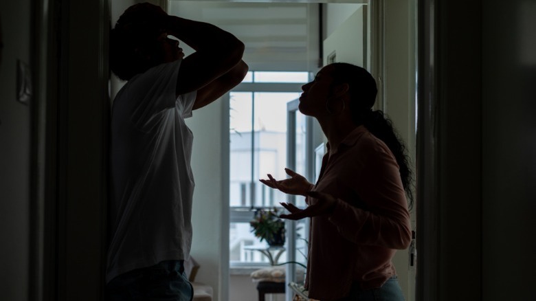 Stressed couple arguing in hallway