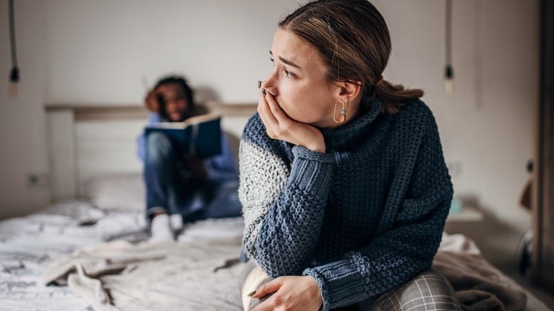 Sad woman sitting on bed