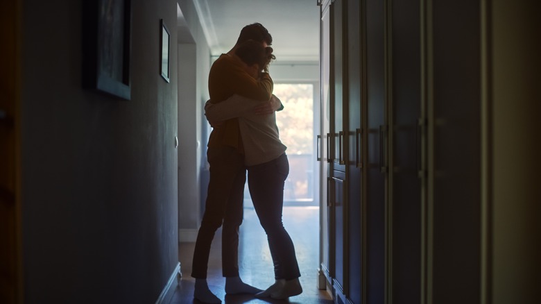 Couple embracing in hallway 