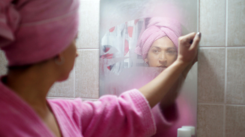 A woman stepping out of a steamy shower