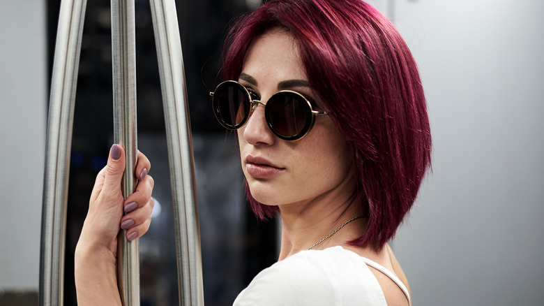 Woman with burgundy hair and sunglasses