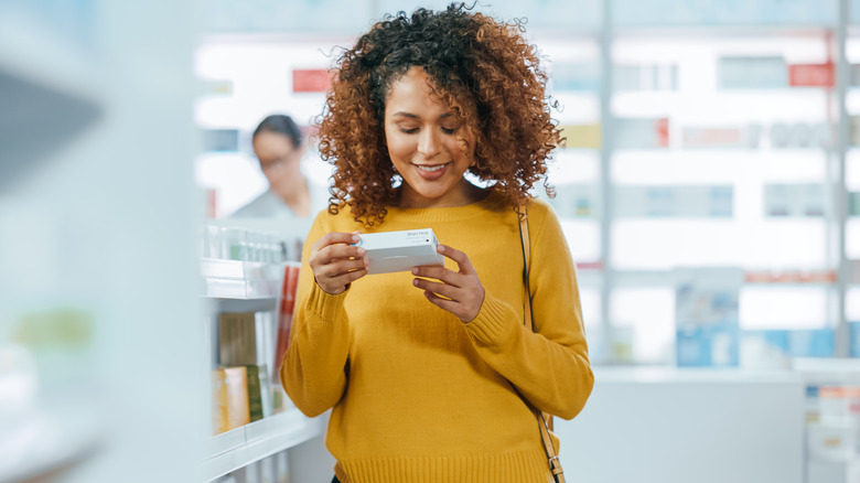 Woman shopping in pharmacy aisle