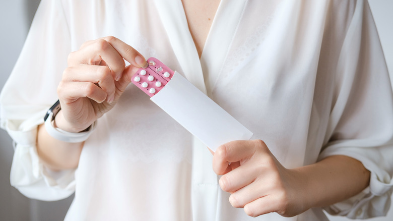 Person holding contraceptive pills