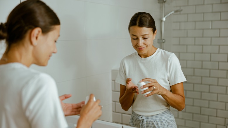 A woman applying a face cream