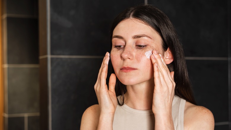 A woman applying a serum