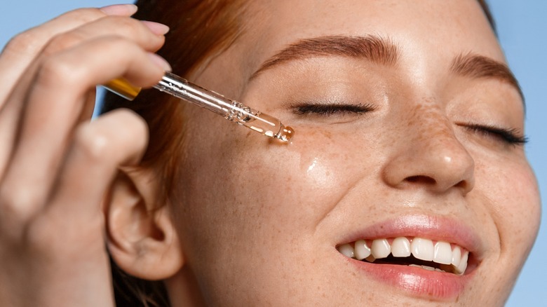 A woman applying serum