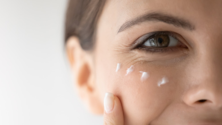 A woman applying skincare product