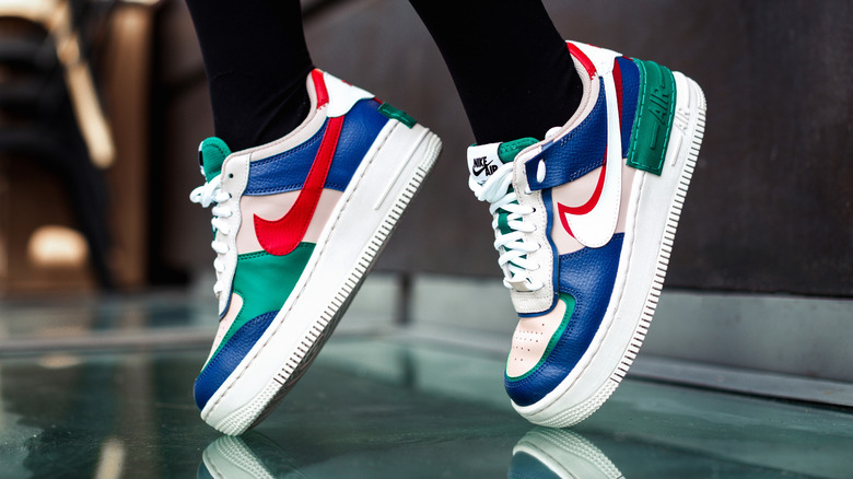 A woman's feet on their tiptoes in vintage Nike Air Force 1s.