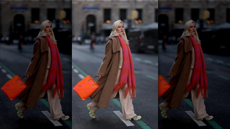 Woman wearing trench coat, sneakers