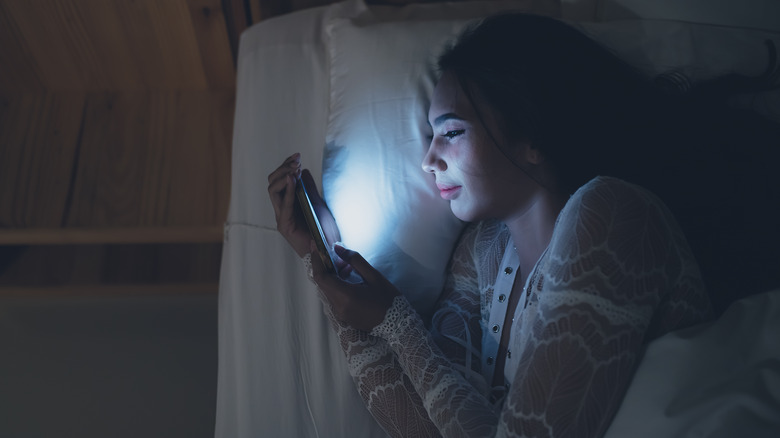 Woman in bed with phone