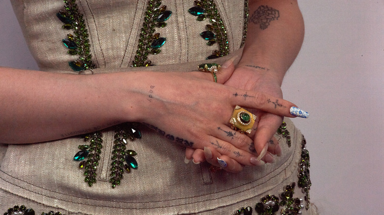 woman wearing chunky gold ring finger tattoos