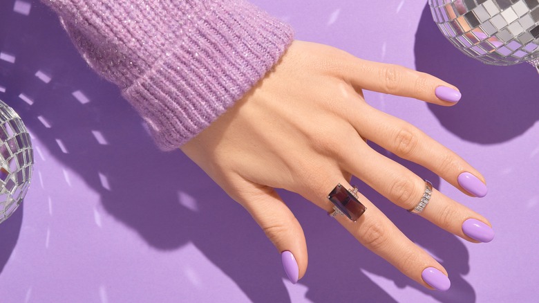 woman's hands wearing purple fashion ring