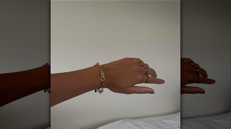 woman's hands with chunky gold rings bracelet