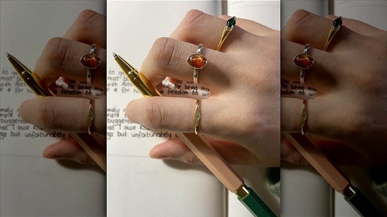 woman wearing mixed gemstones rings