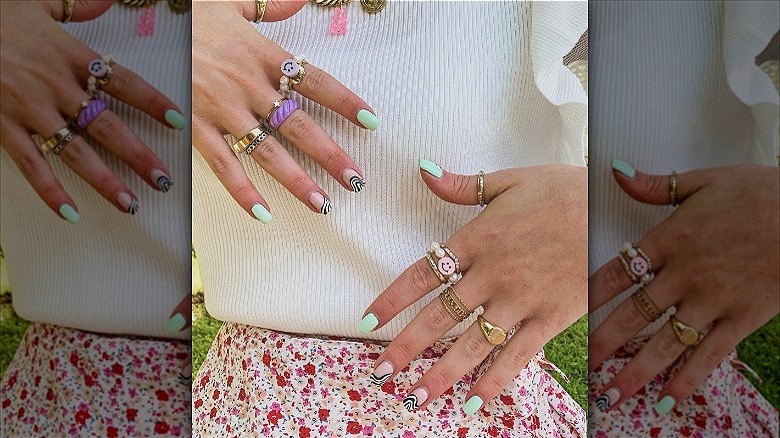 woman's hands wearing colorful fashion rings