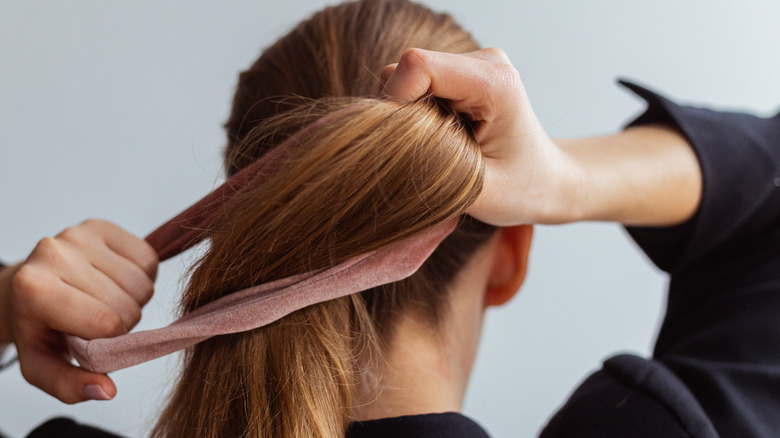 Woman securing hair tie on hair 
