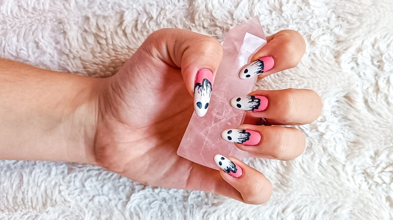 woman with nails holding rose quartz